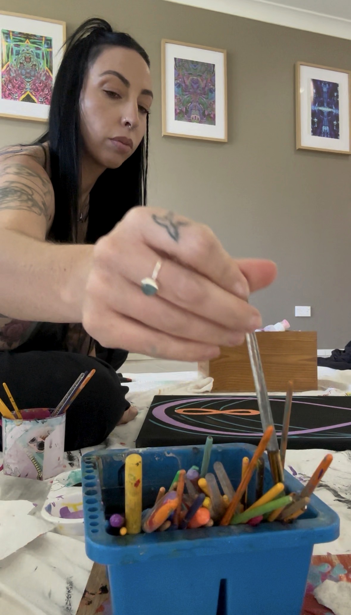 Natalie Merino selecting a brush while painting an original Lightcode